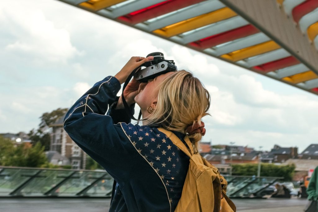 Une demoiselle prend en photo l'oeuvre de Buren à la gare de Liège-Guillemins