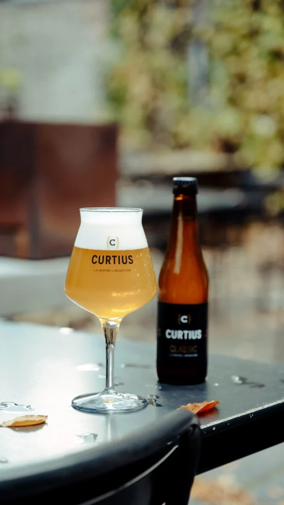 La nouvelle bière Curtius designée par l'agence Braconnier, à côté de son verre